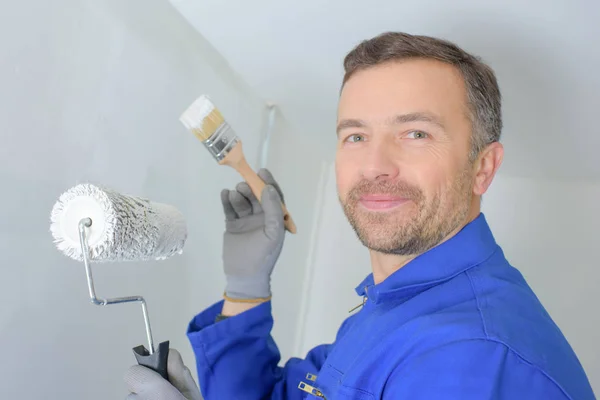 friendly handsome painter painting a wall in a house