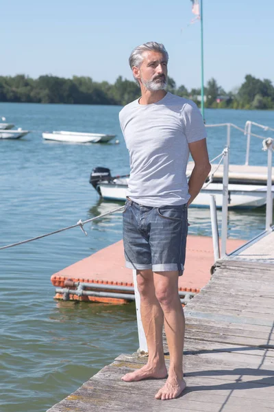 Porträt eines gutaussehenden Mannes auf der Seebrücke, der ruhig wegschaut — Stockfoto