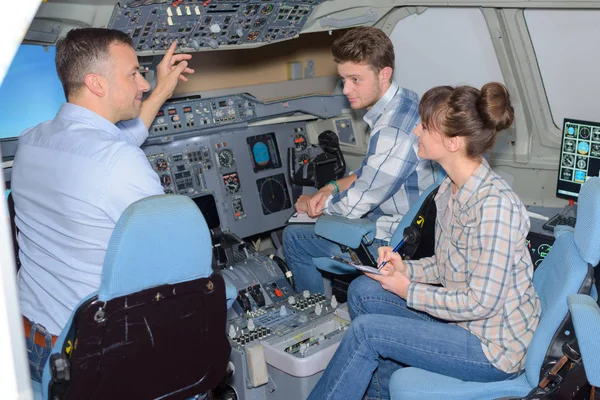 Jovens que visitam um simulador de avião — Fotografia de Stock