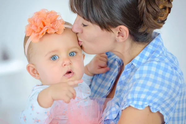 Счастливая мать целуется с новорожденным ребенком — стоковое фото
