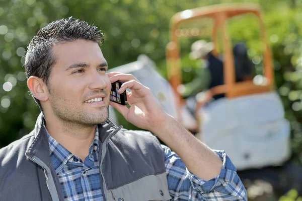 Junger und lächelnder Arbeiter am Telefon — Stockfoto