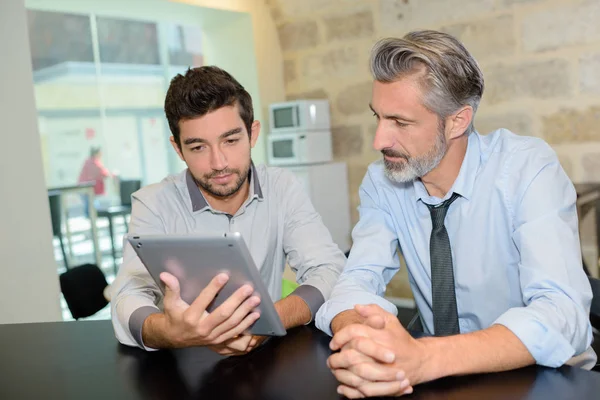 Zwei Männer mit moderner Technik in einer Betriebskantine — Stockfoto