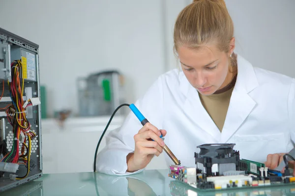 Menina com um testador e uma placa de circuito impresso — Fotografia de Stock
