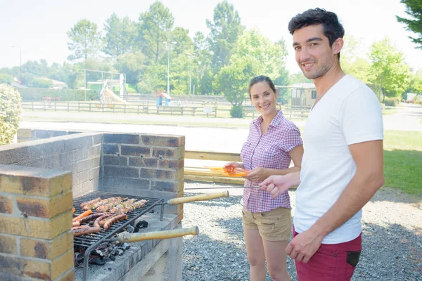 Pareja que tiene barbacoa y barbacoa — Foto de Stock