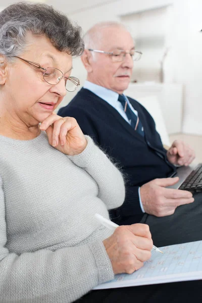 Coppia anziana a casa websurfing sul computer portatile — Foto Stock