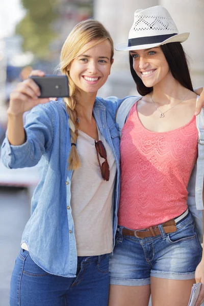 Alegre turista amigas tomando fotos de sí mismas —  Fotos de Stock