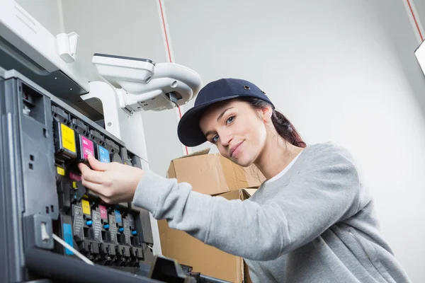 Žena opravuje kazetu v tiskárně v kanceláři — Stock fotografie