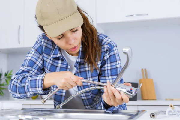 Encanador mulher que fixa uma pia — Fotografia de Stock