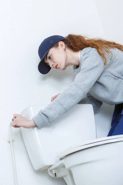 Mulher confiante reparando banheiro no banheiro em casa — Fotografia de Stock