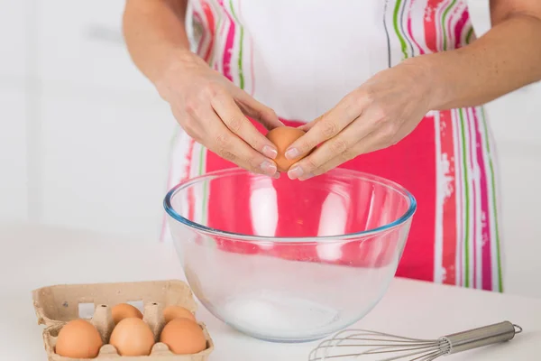 Handen breken een ei in kom op tafel — Stockfoto