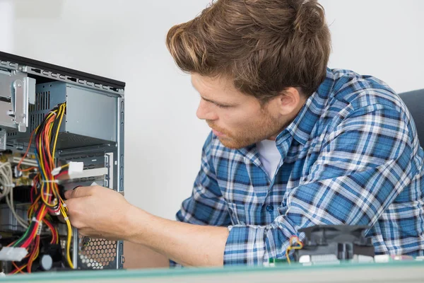 Junger Mann repariert Computer — Stockfoto