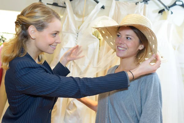 Женщину в свадебном магазине одевают в головной убор — стоковое фото