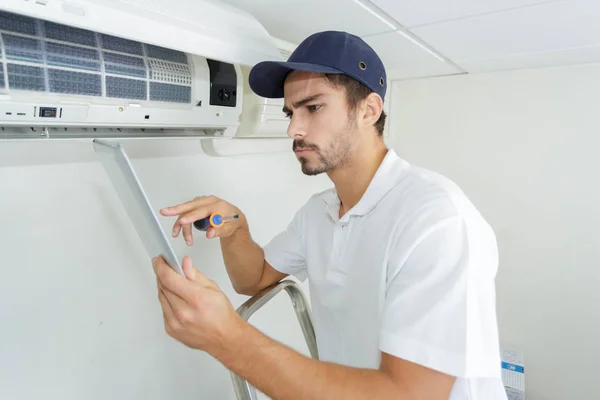 Jonge aannemer werkt zorgvuldig en serieus bij klanten kantoor — Stockfoto