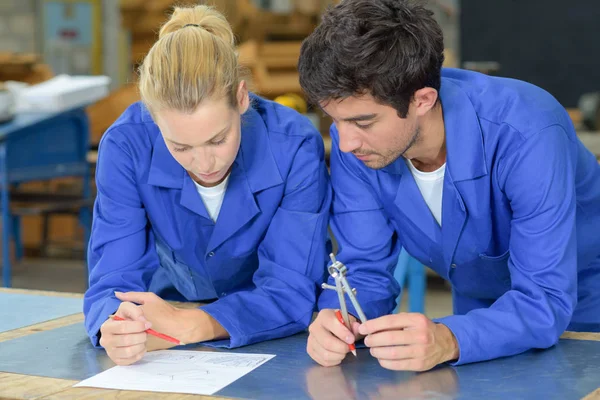 Werknemers kijken plannen, houden een kompas — Stockfoto