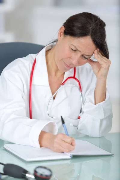 Вдумчивая женщина врач рассматривает состояние пациентов — стоковое фото