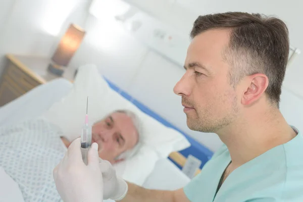 Médico que administra uma injeção a um doente maduro — Fotografia de Stock
