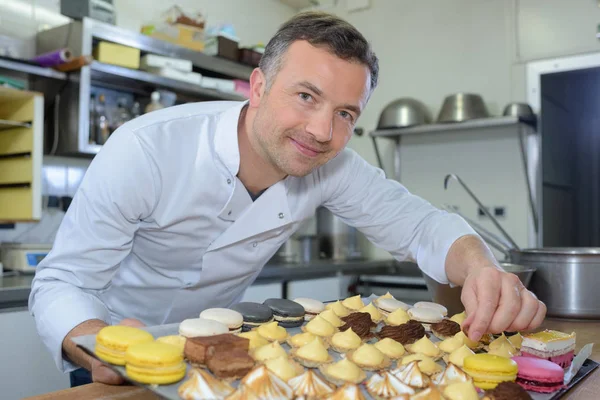 Bäcker hält Blech mit Kuchen — Stockfoto