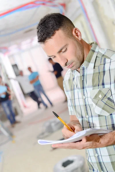 Man making notes, gathering at a construction site — Stock Photo, Image