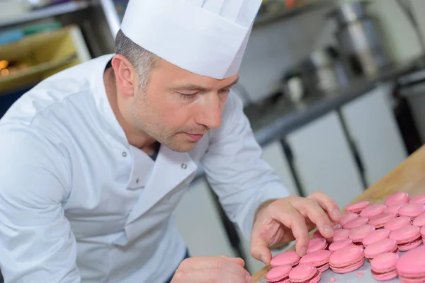 Шеф-повар готовит миндальное печенье и макарон — стоковое фото