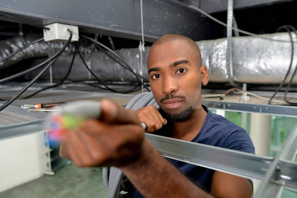 Joven trabajador negro que lleva materiales de construcción —  Fotos de Stock