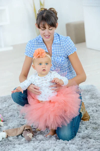 Mutter zieht ihr schönes Baby an — Stockfoto