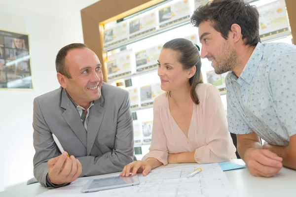 Estate agent in consultation with young couple — Stock Photo, Image