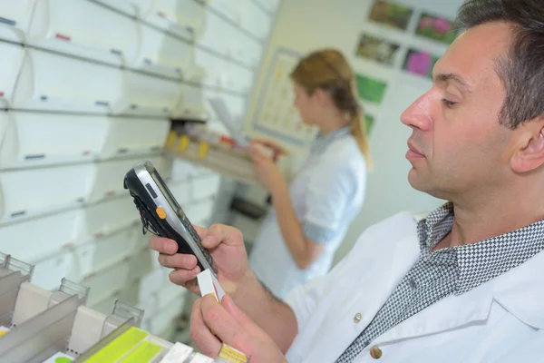 Farmacêutico que seleciona medicamentos e farmacêutico — Fotografia de Stock