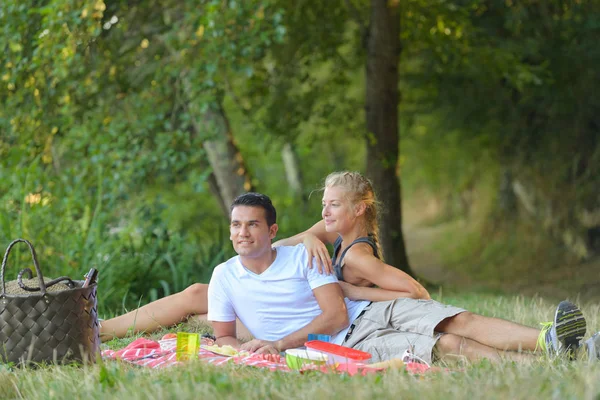 Beautiful young couple having picnic in countryside — Stock Photo, Image