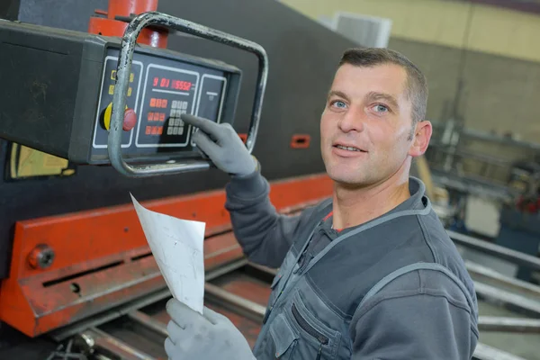 Technicien usando um dispositivo eletrônico na fábrica — Fotografia de Stock