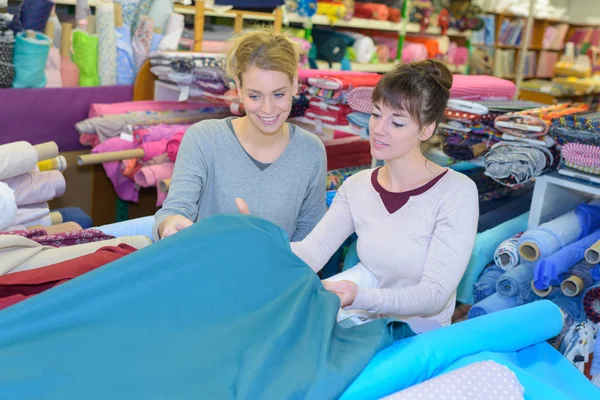 Mujer elige restos de tejido de color en la mesa de cerca —  Fotos de Stock