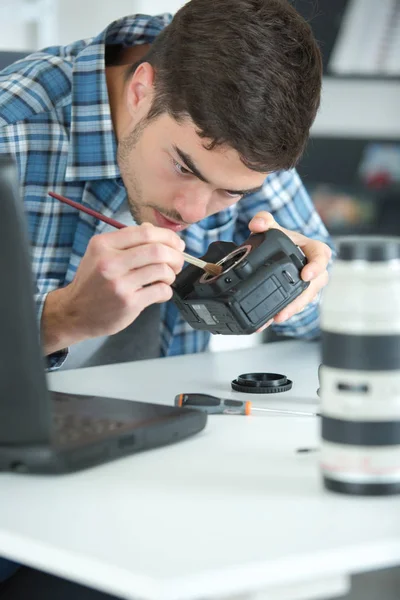 Photographer cleaning lens of his digital camera — Stock Photo, Image