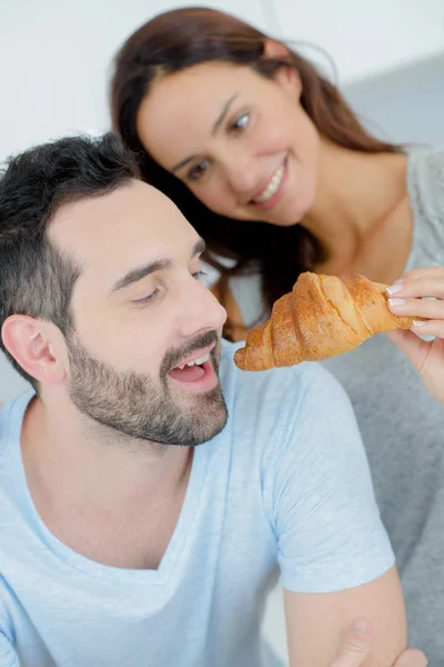 Romantiska par delar en croissant — Stockfoto