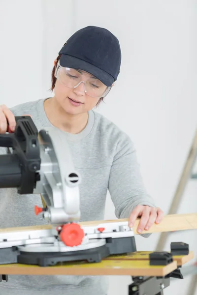 Tagliere donna adulta in officina Immagine Stock