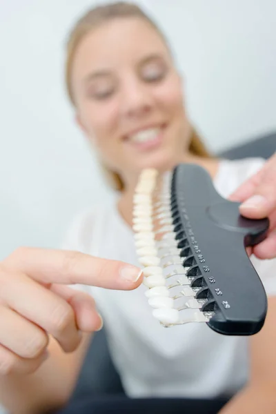 Lady pointing to tooth on color match sampler — Stock Photo, Image