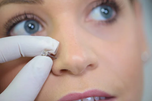 Girl getting a piercing — Stock Photo, Image