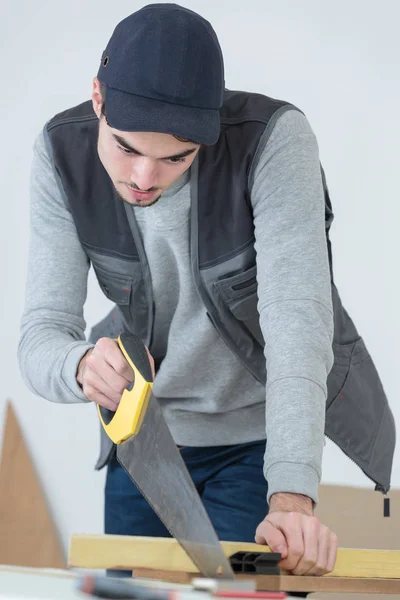 Cutting a wood using a saw — Stock Photo, Image