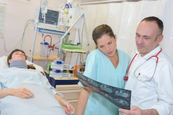 Medici che esaminano i pazienti radiografia in camera d'ospedale — Foto Stock