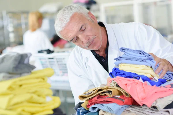 Hombre con montón de ropa — Foto de Stock