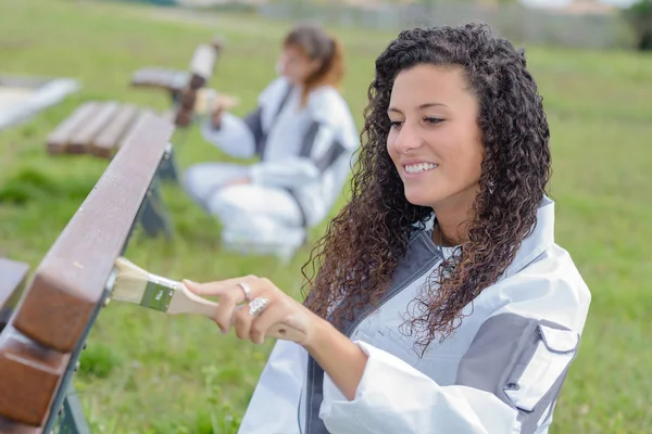 Women painting wooden bench — Stock Photo, Image