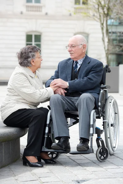 Homem velho em cadeira de rodas com esposa ao ar livre — Fotografia de Stock