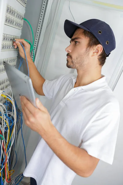 Eletricista focado aplicando procedimento de segurança enquanto trabalhava no painel elétrico — Fotografia de Stock