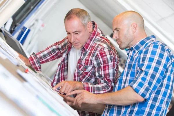 Byggnadsarbetare diskutera planen av byggnaden i office — Stockfoto