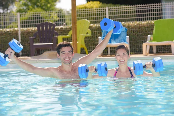 Mann und Frau mit Schwimmhilfen im Pool — Stockfoto