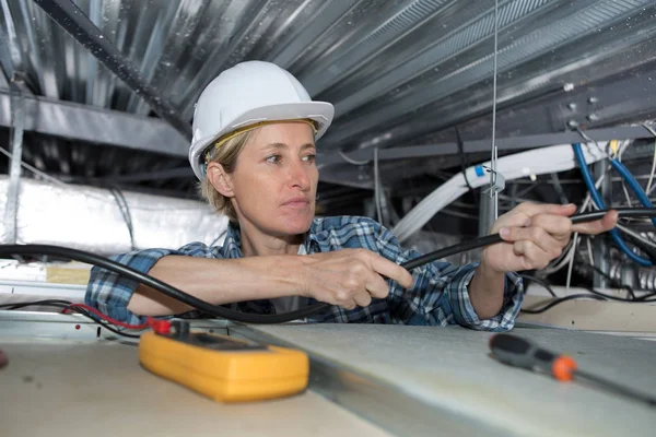 Eletricista feminina com cabos — Fotografia de Stock