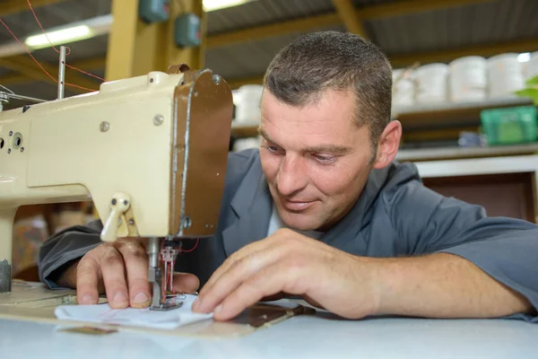Man on sewing machine — Stock Photo, Image