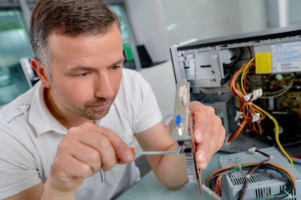 Mann arbeitet mit Schraubenzieher am Computer — Stockfoto
