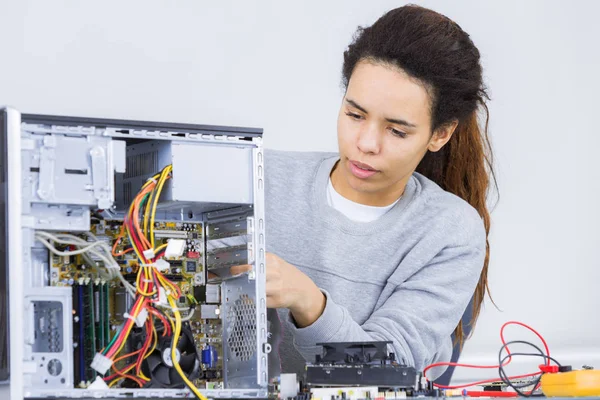 Mujer joven que intenta reparar un ordenador — Foto de Stock