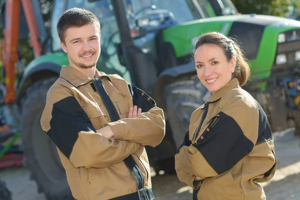 Estudiantes granjeros posando delante del tractor — Foto de Stock