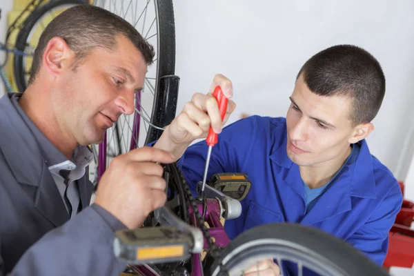 Adolescente em formação profissional de reparação de bicicleta — Fotografia de Stock
