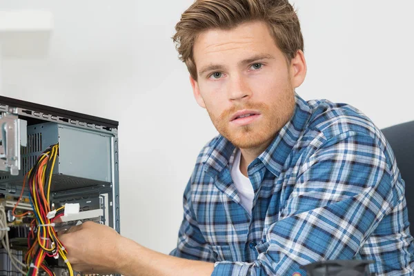 Junger Mann repariert Computer — Stockfoto